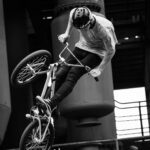 A young boy playing with his bicycle in sporty manner